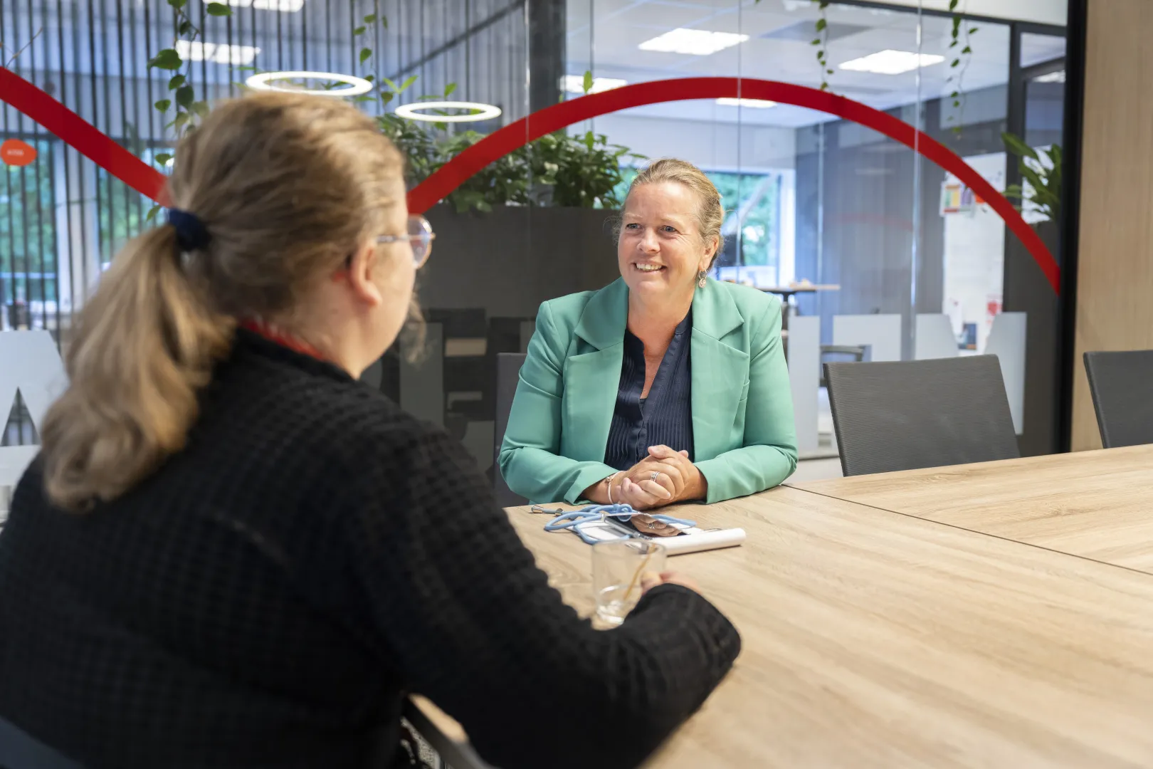 Twee mensen van WSD zitten aan een tafel en zijn in gesprek met elkaar.