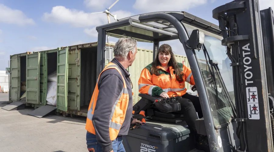 Dame op heftruck praat met collega